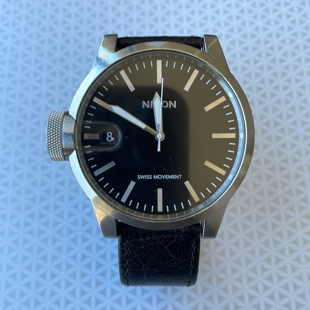 Nixon magnified steel watch with leather band.
